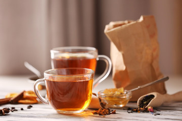 Glass cup of tea with spices on blurred background