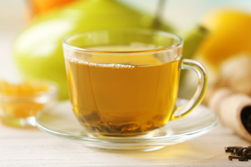 Glass cup of green tea with lemon and leaves on wooden table closeup