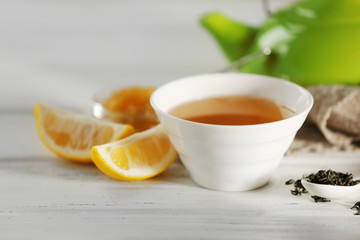 Glass cup of green tea with lemon on wooden table closeup