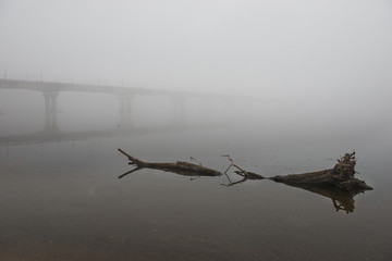 Bridge through river in misty morning
