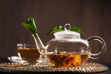 Cup of tea and teapot on a wicker mat