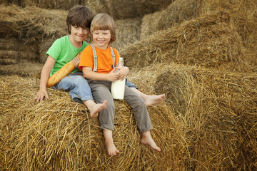 Naklejka na ściany i meble boys on a haystack with bread and milk