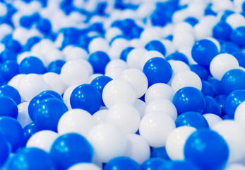 A lot of blue and white plastic balls in playroom.