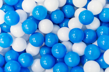 A lot of blue and white plastic balls in playroom.