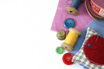 items for needlework/button needle thread thimble cloth meter on a white background