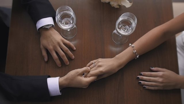 Closeup Toned  of Bride and Groom Holding Hands at Restaurant