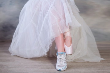 Legs of a ballerina, one foot shod in sneakers other in pointe shoes, lifestyle, hobbies, dancing,...