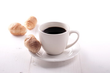 white classic cup of coffee and a croissant
