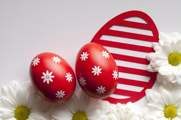 Red Easter eggs and flowers on white background