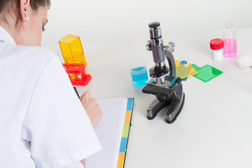 Female teenage student using microscope in science class