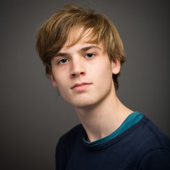 Confident Teenage Blond Young Man In The Studio