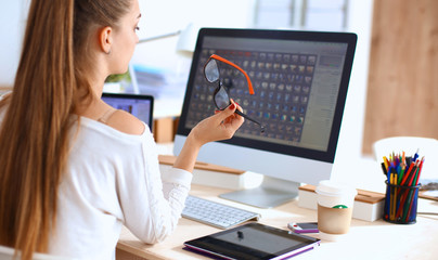 Young woman working in office, sitting at desk