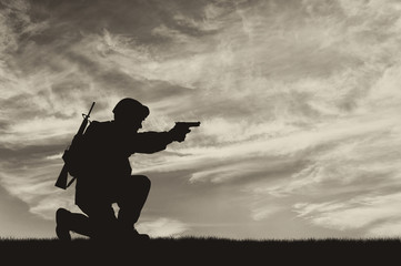 Silhouette of man with weapon against cloudy sky