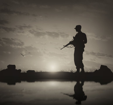 Silhouette of man with weapon against cloudy sky