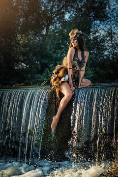 Stunningly beautiful leggy Amazon posing on a river waterfall