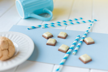 Fototapeta na wymiar cookies on a white plate and pieces of chocolate on white blue background