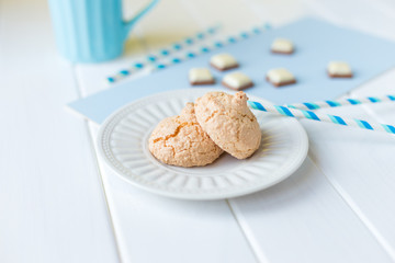 cookies on a white plate and pieces of chocolate on white blue background