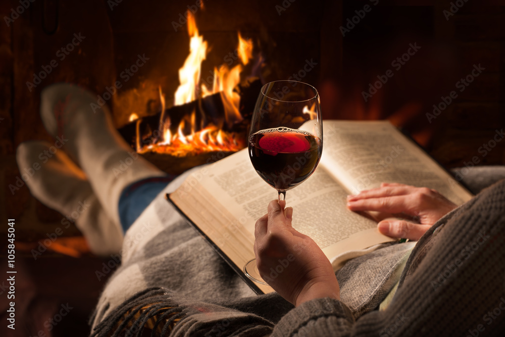 Wall mural woman reads book near fireplace