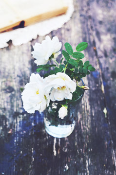 White wild roses bunch in a glass