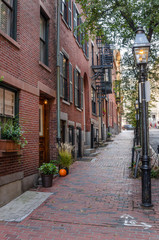 Renovated Town Houses along a sidewalk with Gas Lit Street Lights 