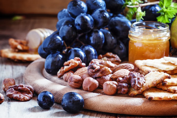 Snack plate: grapes, pears, hazelnuts, almonds, walnuts, cheese