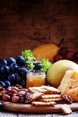 Snack plate: grapes, pears, hazelnuts, almonds, walnuts, cheese