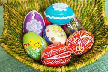 Closeup of beautiful colorful hand painted easter eggs in basket. Selective focus
