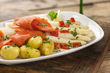  Spargel mit Sauce Vinaigrette, Lachs und Kartoffeln auf weißem Teller