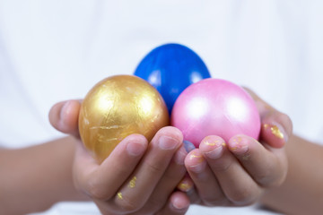 Painting Colorful Easter eggs for the holiday, hands holding egg