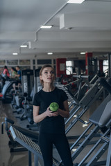 Fototapeta na wymiar Beautiful girl holding a shaker in the gym