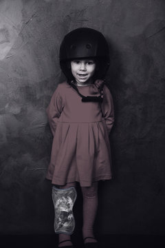 small girl in a red dress and helmet  in studio. Black and white
