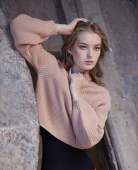 A  woman in a black panties and cream pullover.