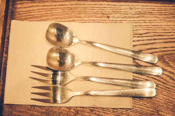 Fork, spoon, small spoon on wooden background