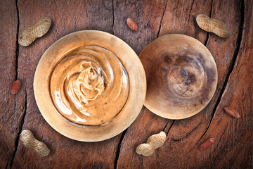 Peanuts in a wooden pot on a wooden table, peanuts, closeup.