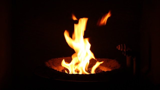 The fire in the furnace. Heating system. Solid fuel boiler. Open fire.