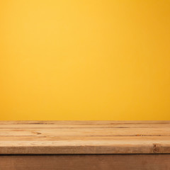 Empty wooden deck table over yellow wallpaper background