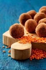 Homemade vegan truffles made with lentils and raw lentils on woo