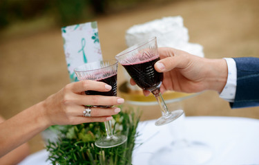 Man and woman drinking red wine. close-up hands with glasses. They are celebrating their wedding anniversary. 