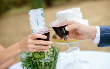 Man and woman drinking red wine. close-up hands with glasses. They are celebrating their wedding anniversary. 