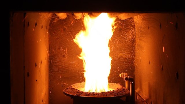 The fire in the furnace. Heating system. Solid fuel boiler. Open fire.