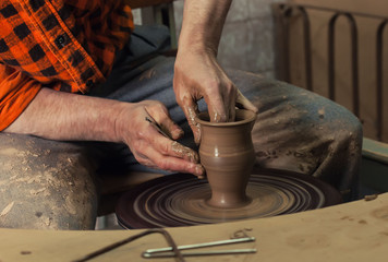 hands making pottery on a wheel