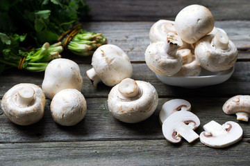Fresh mushrooms champignons on wooden background