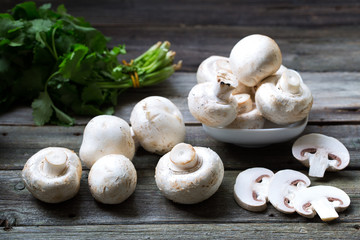 Fresh mushrooms champignons on wooden background