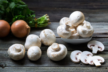 Fresh mushrooms champignons on wooden background