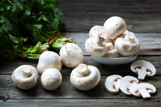 Fresh mushrooms champignons on wooden background