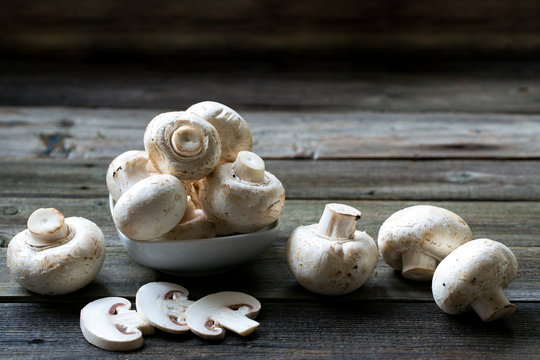 Fresh mushrooms champignons on wooden background