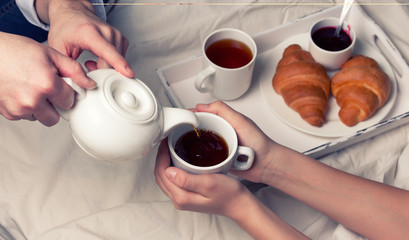 breakfast in bed with tea and croissants 