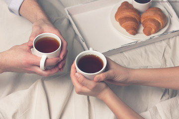 breakfast in bed with tea and croissants 
