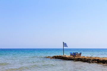 Greek flag at the end of a jetty on the island Zakynthos in summer