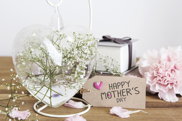 Gypsophila flowers in heart bottle with happy mothers day on pap